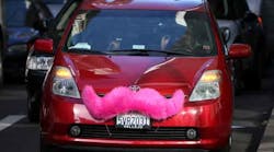 A Lyft car with the company&apos;s trademark pink mustache.