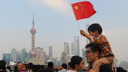 A Chinese boy waves a national flag from atop his fathers shoulders A Chinese boy waves a national flag from atop his fathers shoulders