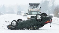 A flipped sedan blocks traffic in the snow A flipped sedan blocks traffic in the snow