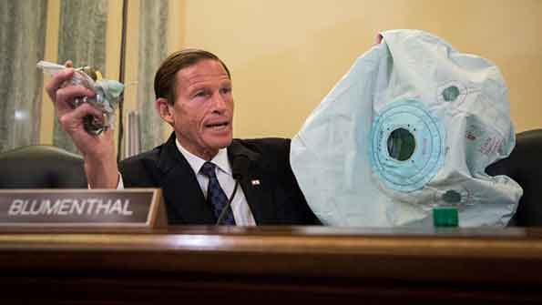 US Sen Richard Blumenthal DCT holds up an airbag and inflator during a Senate hearing on defective Takata airbags last June