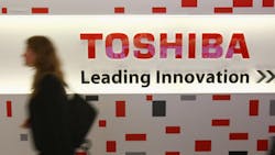 A woman walks pasts a Toshiba sign at a German tech fair A woman walks pasts a Toshiba sign at a German tech fair