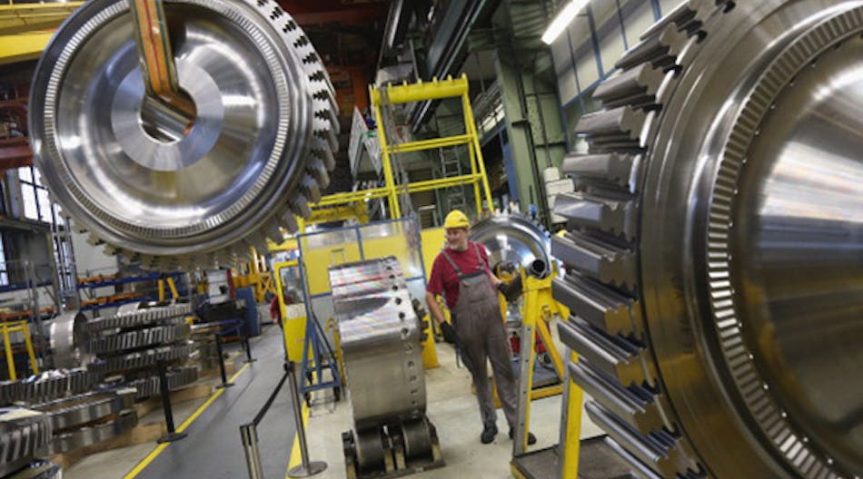 Inside a Siemens gas turbine plant in Berlin, a worker controls a winch to transport a gas turbine disc. The German economy has taken an unexpected turn after industrial production dropped in December.