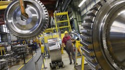 Inside a Siemens gas turbine plant in Berlin a worker controls a winch Inside a Siemens gas turbine plant in Berlin a worker controls a winch