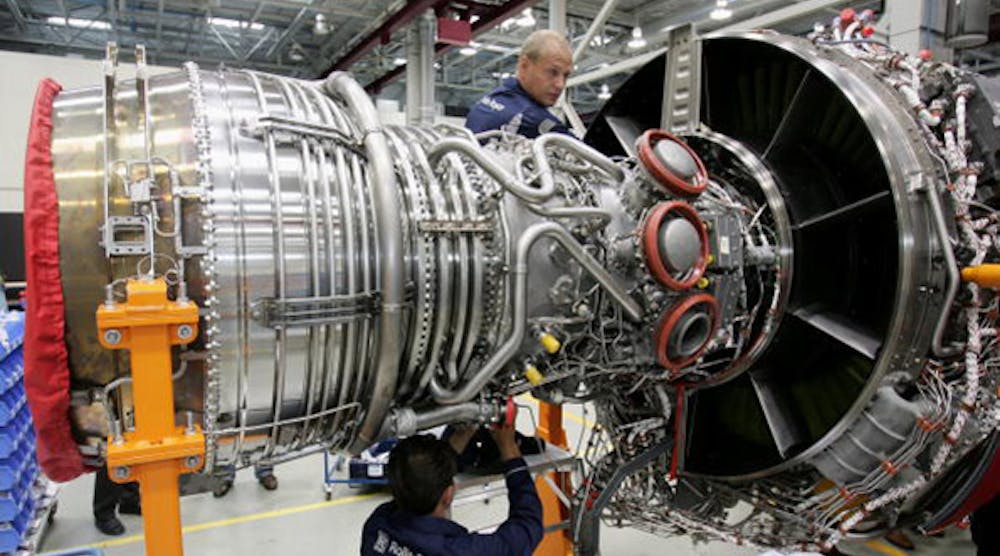 Rolls-Royce workers assemble an aircraft jet engine in a Berlin factory. The company cut its dividends Friday for the first time in almost a quarter of a century, but shares still rallied 16%.
