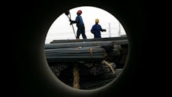 Workers unload steel at a products exchange market Workers unload steel at a products exchange market