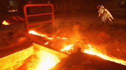 A worker punches a hole into an outlet for slag from molten iron ore flowing from a ThyssenKrupp blast furnace. Iron ore prices jumped almost 20% Monday.