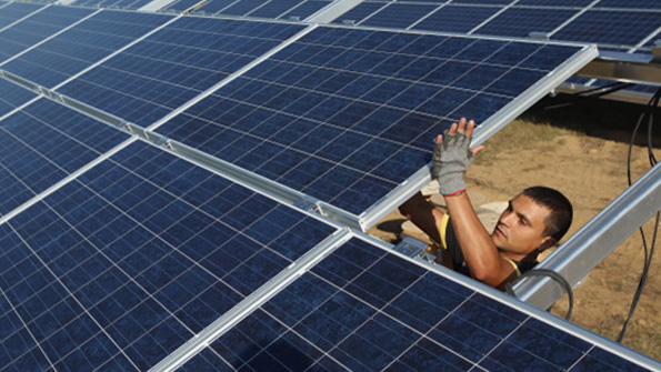 A worker installs solar panels in a German park