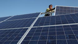 A German worker installs solar panels A German worker installs solar panels