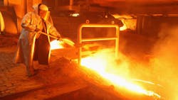 A ThyssenKrupp worker shovels sand into slag from molten iron ore A ThyssenKrupp worker shovels sand into slag from molten iron ore
