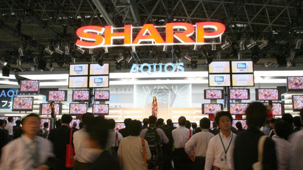 Attendees at an electronics show mill around the Sharp booth