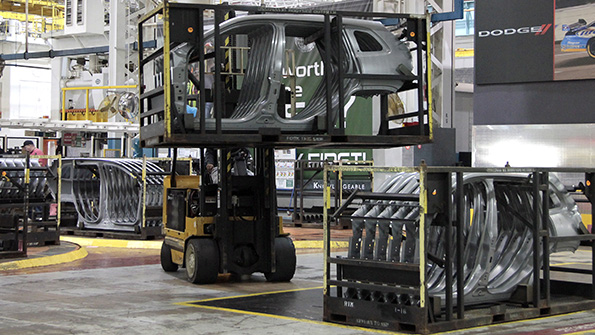A forklift driver moves the racks of Jeep Cherokee body side panels at the FCA Sterling Stamping Plant