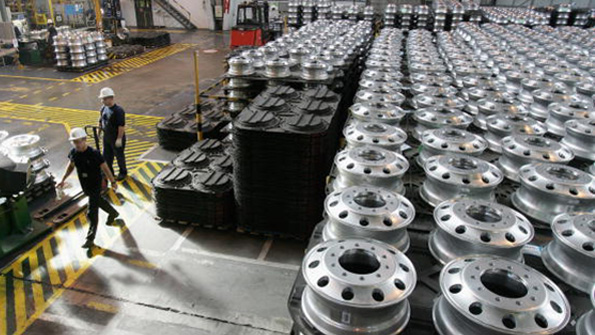 Workers walk the floor of a Hungarian Alcoa factory