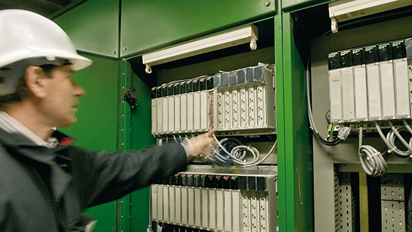 A Schneider Electric worker looks at an Ethernet hookup