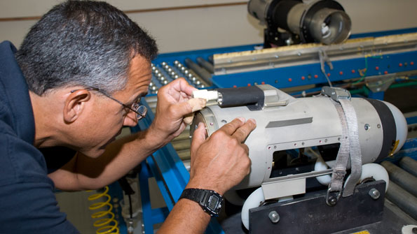A Lockheed Martin team member applies sealant to a Javelin missile body