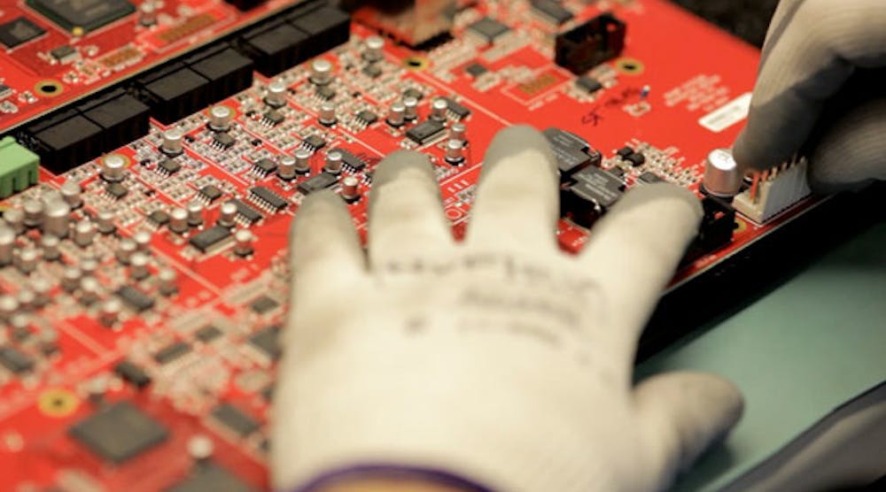 A Biamp System&apos;s employee places connectors on a Nexia board for soldering
