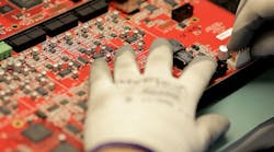 A Biamp System&apos;s employee places connectors on a Nexia board for soldering