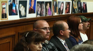 Pictures of people killed when their cars&apos; ignition switches malfunctioned are displayed by family members while General Motors CEO Mary Barra testifies at a House Energy and Commerce Committee hearing in June. (Photo by Mark Wilson/Getty Images)