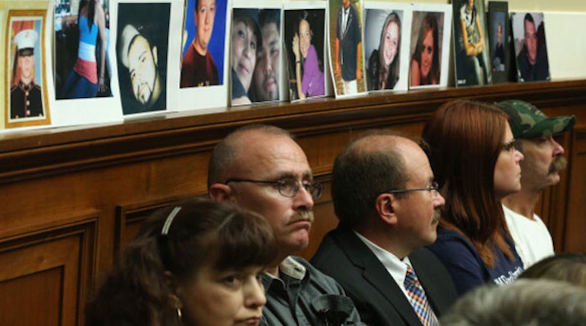 Pictures of people killed when their cars&apos; ignition switches malfunctioned are displayed by family members while General Motors CEO Mary Barra testifies at a House Energy and Commerce Committee hearing in June. (Photo by Mark Wilson/Getty Images)