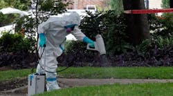 A hazmat worker treats the sidewalk in front of an apartment where a health care worker diagnosed with the Ebola virus resides on October 12 in Dallas. (Photo by Mike Stone/Getty Images)