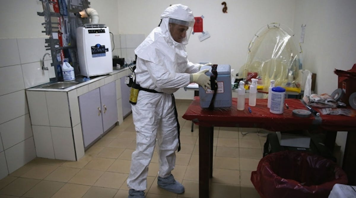 U.S. Navy microbiologist Lt. Jimmy Regeimbal handles a vaccine box with blood samples while testing for Ebola at the U.S. Navy mobile laboratory near Gbarnga, Liberia, on October 5. The U.S. now operates 4 mobile laboratories as part of the American response to the Ebola epidemic. (Photo by John Moore/Getty Images)