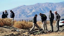Agents from the National Transportation Safety Board and the FBI comb through the wreckage of the Virgin Galactic SpaceShip 2 in a desert field north of Mojave, California, on November 2. (Photo by Sandy Huffaker/Getty Images)