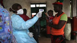 A Liberian Ministry of Health worker checks people for Ebola symptoms at a checkpoint near the international airport on August 24, 2014, near Dolo Town, Liberia. (Photo by John Moore/Getty Images)
