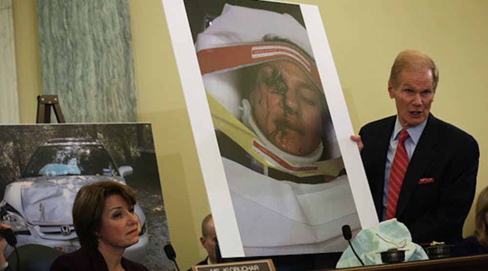 Sen. Bill Nelson, chairman of the Senate Commerce Committee, holds a photo of a woman who suffered facial injuries when an airbag exploded in her car in a traffic accident last year. The committee held a hearing last week to examine defects in airbags manufactured by Takata and their recall process. (Photo by Alex Wong/Getty Images)