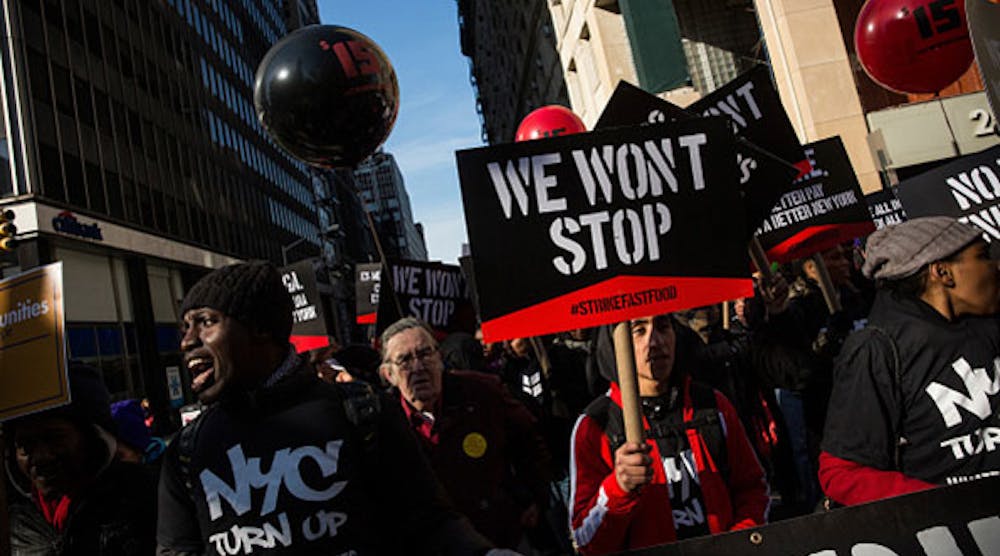 Protesters march through the streets of New York today demanding a raise on the minimum wage to $15 per hour. (Photo by Andrew Burton/Getty Images)