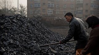 Chinese laborers work at a coal depot, which manufactures coal used for cooking and heating, on November 21, 2014, in Hebei outside Beijing, China. (Photo by Kevin Frayer/Getty Images)