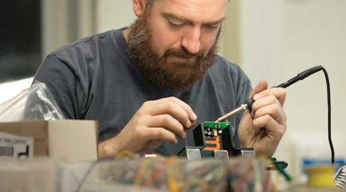 Tim Gillespie, electronics community manager, solders control boards in the FirstBuild lab where community members come together to build prototypes of next generation appliances.