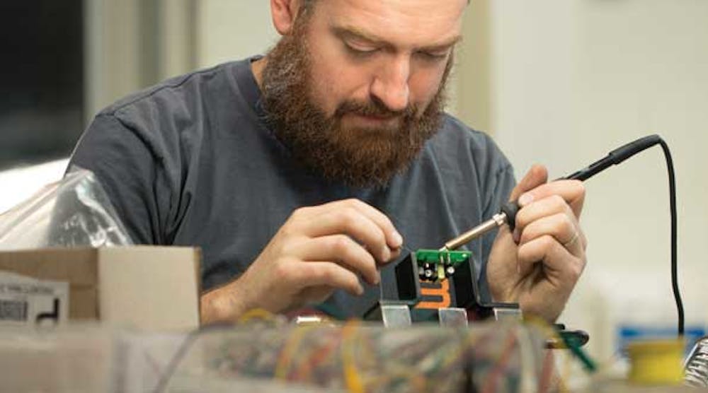Tim Gillespie, electronics community manager, solders control boards in the FirstBuild lab where community members come together to build prototypes of next generation appliances.