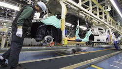 A worker inspects a car on the line at a Toyota Factory in ToyotaShi Japan A worker inspects a car on the line at a Toyota Factory in ToyotaShi Japan