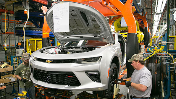 Workers install wheels and tires on a preproduction 2016 Chevrolet Camaro for testing at the Grand River Assembly Plant in Lansing