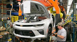 Workers install wheels and tires on a pre-production 2016 Chevrolet Camaro for testing at the Grand River Assembly Plant in Lansing,