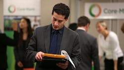 A job seeker reviews information at a fair A job seeker reviews information at a fair