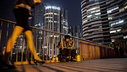 A Chinese busker plays in the shadow of skyscrapers A Chinese busker plays in the shadow of skyscrapers