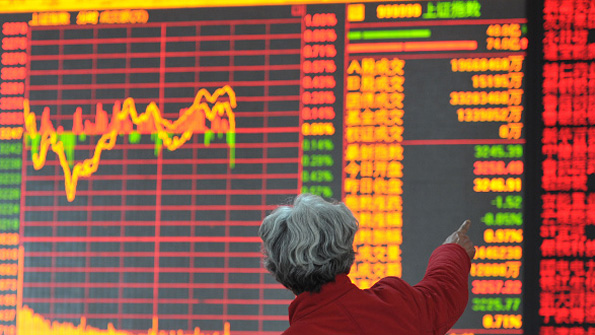 An investor looks at Asian stocks