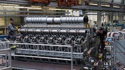 Workers build a heavyduty diesel engine Workers build a heavyduty diesel engine