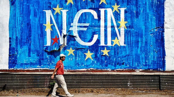 A man walks past antiEU graffiti in Athens