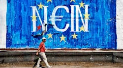 A man walks past anti-EU graffiti in Athens.