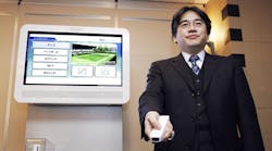Satoru Iwata, the president and CEO of Nintendo until his death Saturday, demonstrates the Wii at an event in December 2006.
