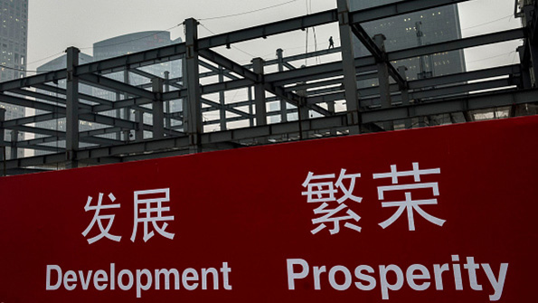 A banner at a Chinese construction site reads Development Prosperity