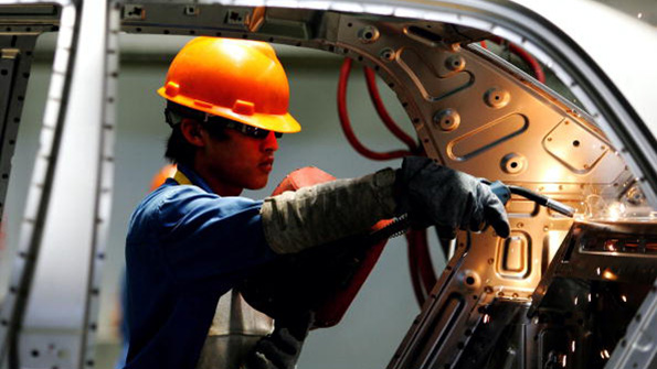 An employee works on an assembly line at the Zhejiang Geely Automobile Company