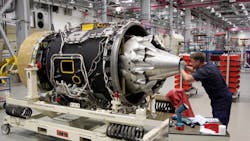 A worker peers inside an aircraft jet engine A worker peers inside an aircraft jet engine