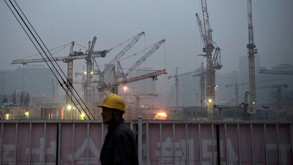 A Chinese laborer stands outside a worksite