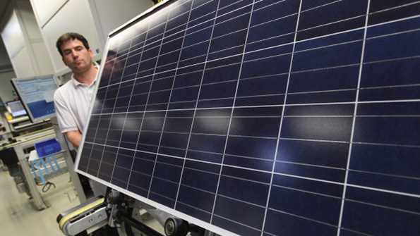An Aleo worker tests a solar panel