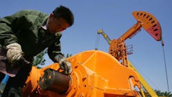 A laborer repairs an oilpumping unit A laborer repairs an oilpumping unit