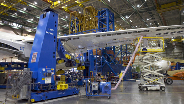 A Boeing employee works on the wing of a Boeing 787 Dreamliner