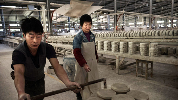 A pair of workers push a cart at a factory in Dehua China
