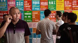 Job seekers look at ads outside an employment center in the city of Yiwu, China.